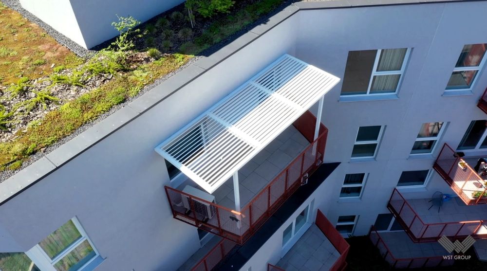 Nowoczesne zadaszenie balkonowe z aluminiowymi lamelami na balkonie w budynku wielorodzinnym