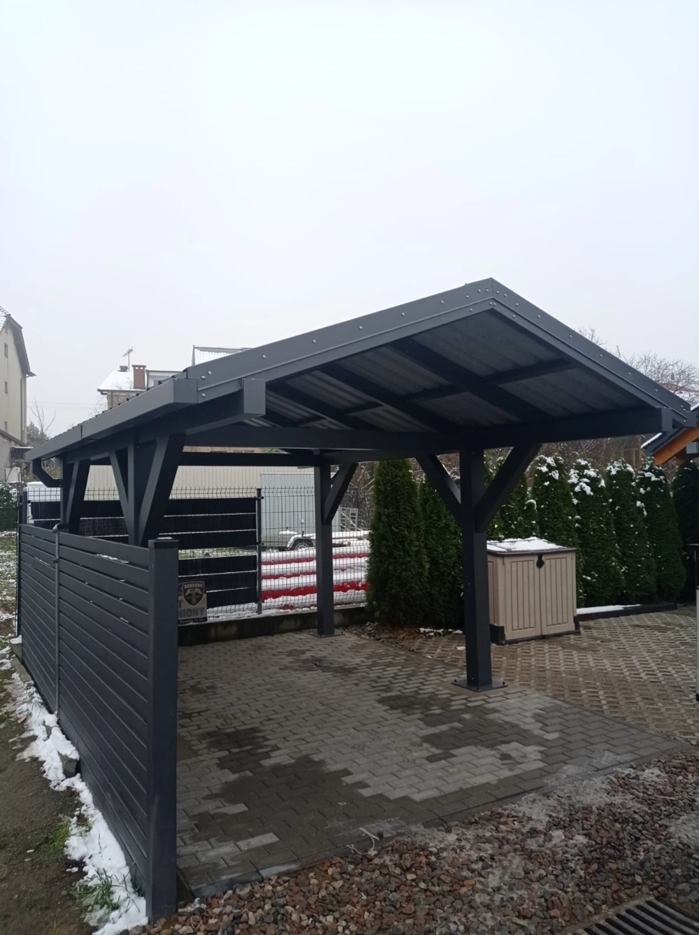 Wiata samochodowa aluminiowa z boczną ścianką ochronną na podjeździe