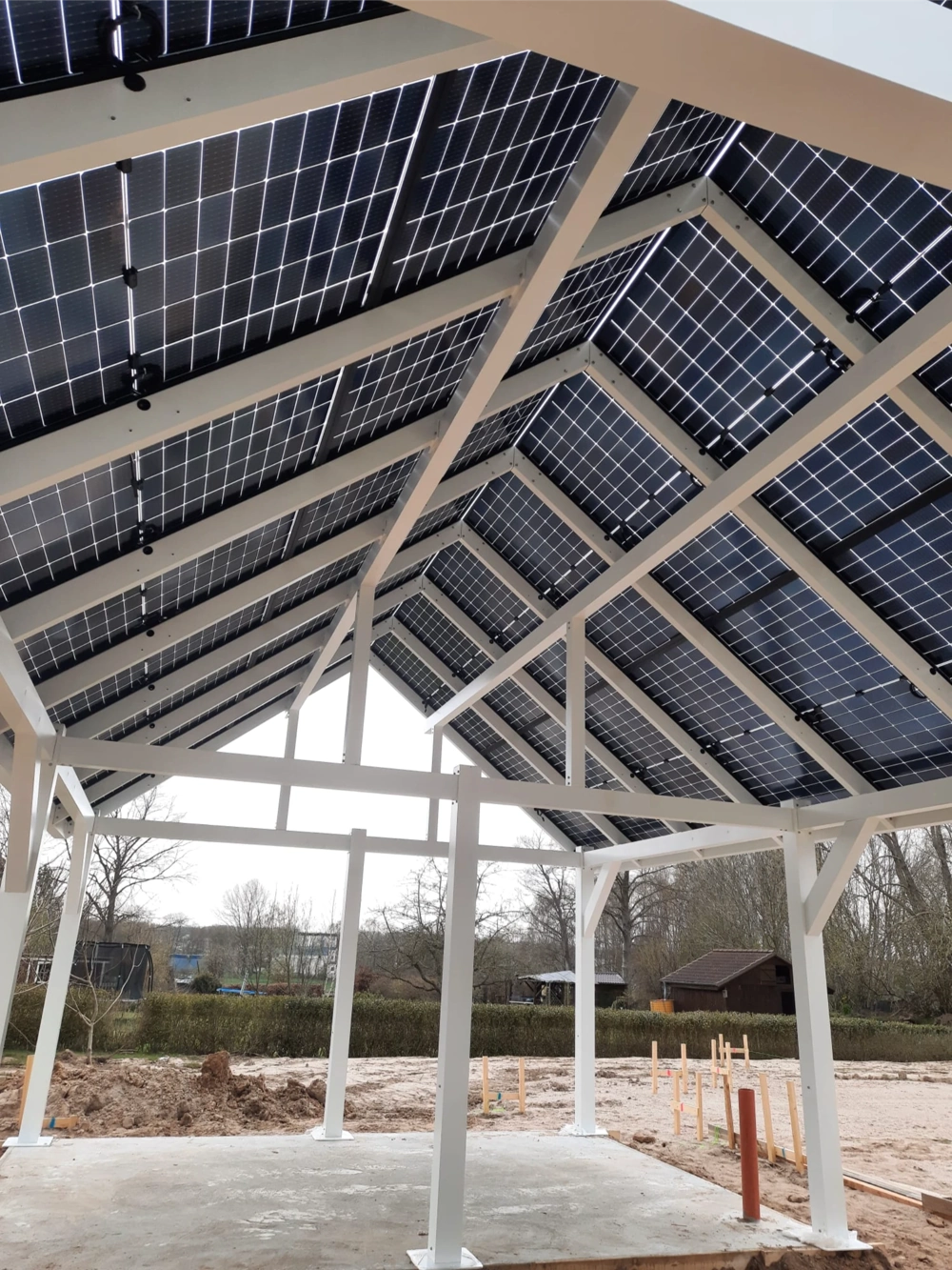 Aluminiowa wiata samochodowa pv z białą stalową ramą i nachylonym dachem z paneli fotowoltaicznych