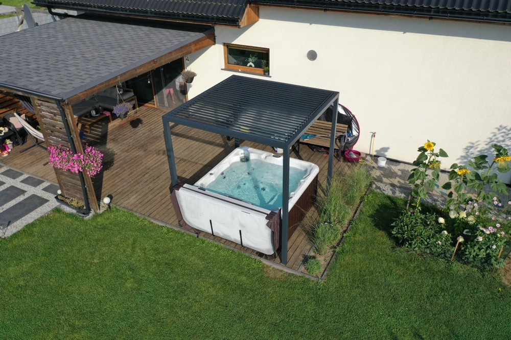 Zadaszenia do spa z regulowanymi lamelami nad jacuzzi na drewnianym tarasie