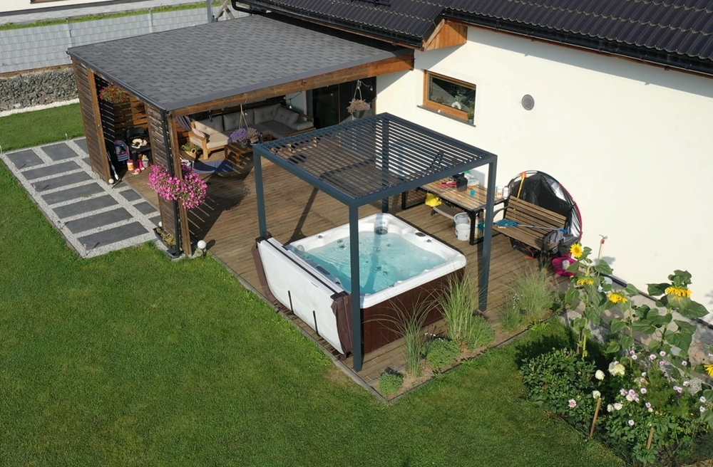 Zadaszenie do spa – aluminiowa pergola z ruchomymi lamelami nad jacuzzi na tarasie z drewnianą podłogą